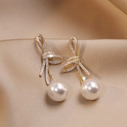 Pearl earrings with a glossy bow in gold 0