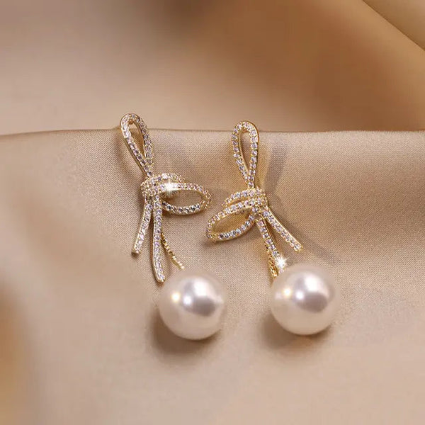 Pearl earrings with a glossy bow in gold 0